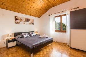 Un dormitorio con una cama y un techo de madera. en Apartments Janet, en Ugljan