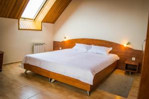 Schlafzimmer mit einem großen Bett mit einem Kopfteil aus Holz in der Unterkunft Hotel Lidia in Aluschta