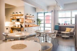 a room with tables and chairs and a kitchen at Dream Hostel & Hotel Tampere in Tampere
