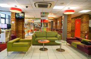 a living room filled with furniture and a red couch at Ibis Styles London Walthamstow in London