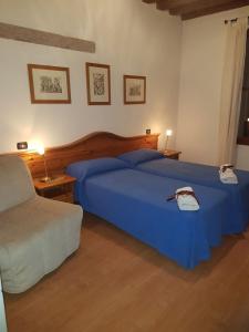 a bedroom with two beds with blue sheets and two lamps at Ristorante Pizzeria al Mondo in Valstagna