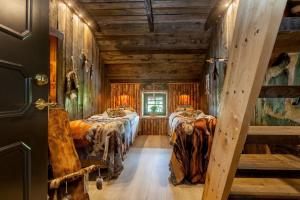 two beds in a room with wooden walls at J A Ranch Bed & Breakfast in Strömsnäsbruk