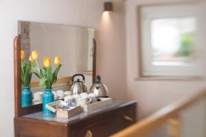 a bathroom vanity with a mirror and flowers on it at Porta della Torre Bed & Breakfast in SantʼAmbrogio di Valpolicella