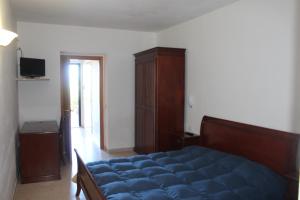 a bedroom with a blue bed and a wooden cabinet at Residence Hotel Torresilvana in Vieste