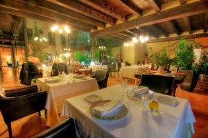 un restaurante con mesas y sillas con mantel blanco en Hotel El Convent 1613, en La Fresneda