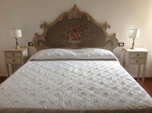 um quarto com uma grande cama branca com duas mesas de cabeceira em Teruzzi Country House em San Gimignano