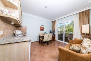 a kitchen and a living room with a table at Lighthouse Apartments in Marmaris