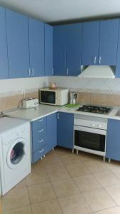 a kitchen with blue cabinets and a washing machine at Apartment Palmar I 50 por ciento dscto direco in Aljucer