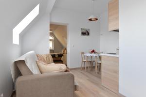 a living room with a couch and a kitchen at Apartament Muszelka in Świnoujście