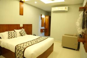 a bedroom with a bed and a air conditioner at 4U Business Hotel in Chennai