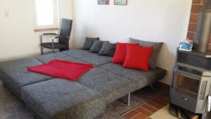Un dormitorio con una cama con almohadas rojas. en Ferienhaus Storchenweg en Mahlzow