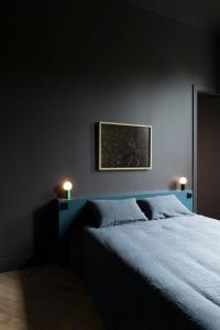 1 dormitorio con 1 cama y 2 luces en la pared en Les Toquées Maison d'hôtes en Lille