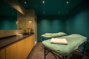 a barber shop with two green chairs and a counter at Best Western Plus Hostellerie Du Vallon in Trouville-sur-Mer