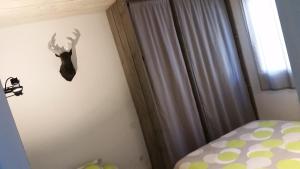 勒卡特海灘的住宿－盧卡特洛克酒店，卧室的墙上设有鹿头