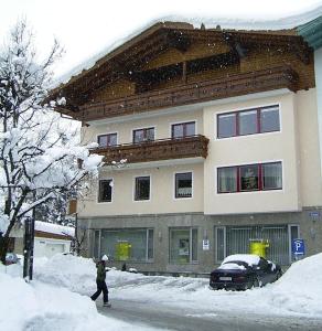 eine Person, die im Schnee vor einem Gebäude läuft in der Unterkunft Appartements Mooslechner in Altenmarkt im Pongau