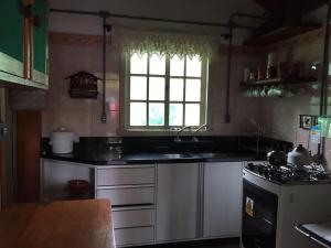 uma cozinha com um lavatório, um fogão e uma janela em Sitio da Paz Celestial em Nova Petrópolis