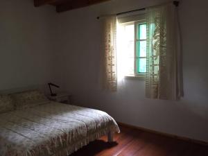 um quarto com uma cama e uma janela em Sitio da Paz Celestial em Nova Petrópolis