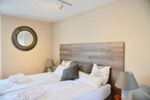 1 dormitorio con 2 camas blancas y espejo en Ruheoase am Bodensee, en Allensbach