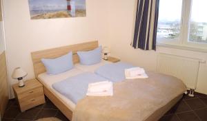 ein Schlafzimmer mit einem Bett mit zwei Handtüchern darauf in der Unterkunft Apartment Leuchtturm 16 in Großenbrode