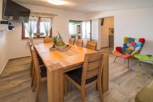 uma cozinha e sala de jantar com uma mesa de madeira e cadeiras em Mobile Homes Residence Ulika em Krk
