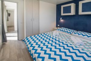 sypialnia z łóżkiem z niebiesko-białą kołdrą w obiekcie Mobile Homes Residence Ulika w Krku