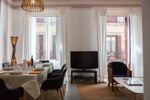 a dining room with a television and a table with chairs at El sitio de Adrian in Madrid