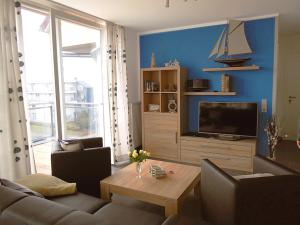 a living room with a couch and a tv at Apartment Leuchtturm 16 in Großenbrode