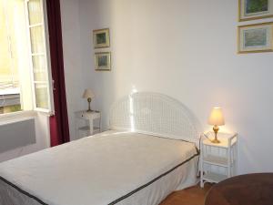 サントロペにあるPort de Saint-Tropezのテーブル2台付きの部屋の白いベッド1台