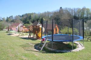 - un parc avec une aire de jeux dotée d'un trampoline dans l'établissement Les Cottages de Charme, à Saint-Aignan