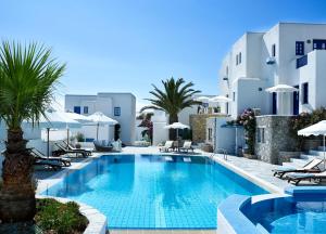 uma piscina com cadeiras e guarda-sóis ao lado de um hotel em Folegandros Apartments em Chora Folegandros