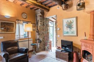uma sala de estar com lareira e televisão em Le Civette e L'Upùpa Country Houses em San Quirico di Moriano