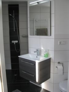 Un baño con lavabo, ducha y espejo. en Ferienhaus Johanna, en Schmalkalden 23 fotos más