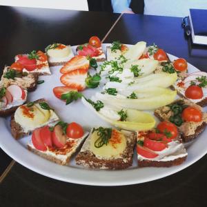un plato de comida con sándwiches y tomates en una mesa en Gutsherrenstube en Großheringen