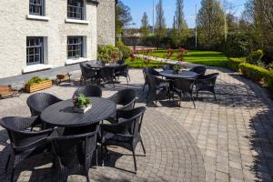 a patio with tables and chairs on a brick patio at The Address Citywest (formerly Kingswood Hotel) in Citywest