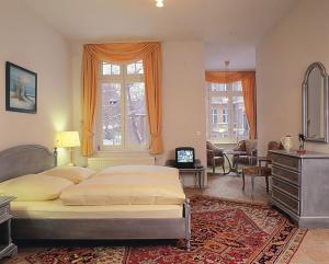 a bedroom with a bed and a desk and a television at Schmiedehaus - Appartement in Heringsdorf