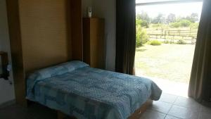 a bedroom with a bed and a large window at Mini Complejo El Encuentro in Sierra de los Padres +27 photos