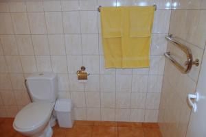 a bathroom with a toilet and a yellow towel at Turnė Guest House in Šiauliai