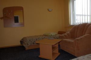 a living room with a couch and a chair at Turnė Guest House in Šiauliai