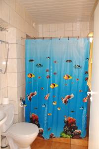a bathroom with a toilet and a shower curtain at Turnė Guest House in Šiauliai