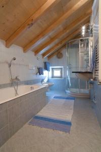 un ampio bagno con lavandino e vasca di Santin Apartments a Livigno