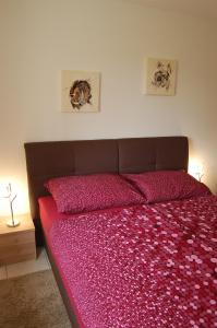 um quarto com uma cama grande e uma colcha rosa em Ferienwohnung Frate em Velden am Wörthersee