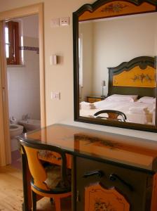 una camera da letto con tavolo da trucco, specchio e letto di Agriturismo Al Dugale a Lazise