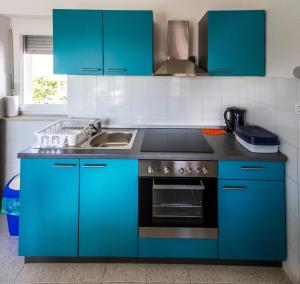 cocina azul con fregadero y fogones en Apartments Borghese, en Pula