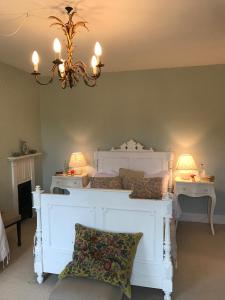 a bedroom with a white bed and two night stands at Ellesmere House in Castle Cary