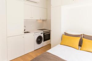 a white room with a bed and a washing machine at Downtown Porto Mouzinho Studio Apts in Porto