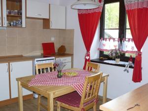 a kitchen with a table with a red and white table cloth at Chalupa Hrabišín in Šumperk
