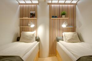2 camas en una habitación con separadores de madera en Dream Hostel & Hotel Tampere, en Tampere