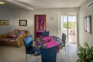 a dining room with a table and blue chairs at Apartments Borghese in Pula