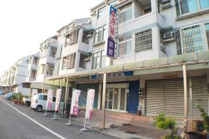 un edificio con letreros frente a él en una calle en Sun Moon Star Hostel en Budai