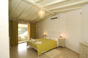 a bedroom with a bed with a yellow bedspread at Villa Contessina in Gaios +10 photos